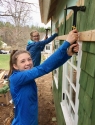 Girls Hammering up Cedar Siding